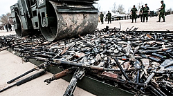 Bulldozer crushes illegally imported cars and bikes - GIF-guns-rolled-over.png